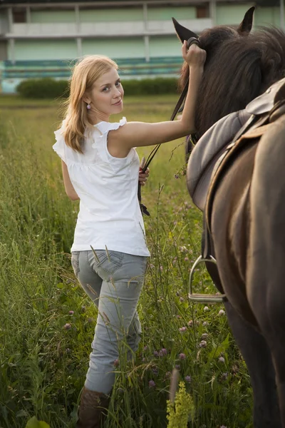 Ung blond kvinna med häst — Stockfoto