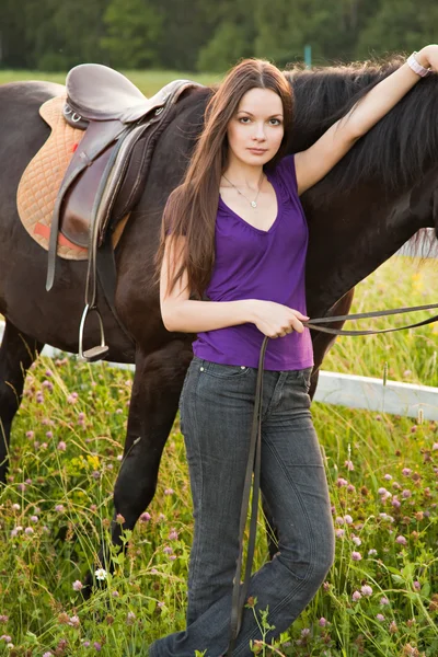 Den unga blonda kvinnan med en häst — Stockfoto