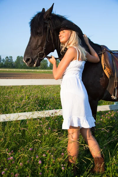 Young blond woman in white dress with horse — Stok fotoğraf
