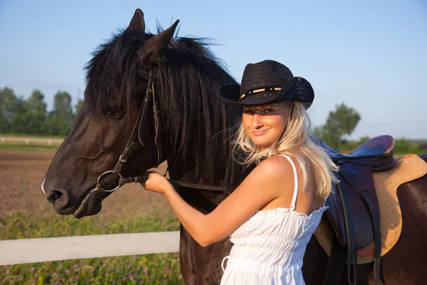 Giovane donna bionda in abito bianco con cavallo — Foto Stock