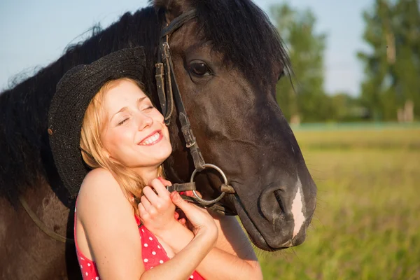 Young blond woman with horse — Stok fotoğraf