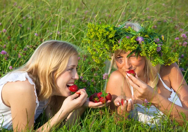 Två unga blonda kvinnor äta jordgubbar — Stockfoto