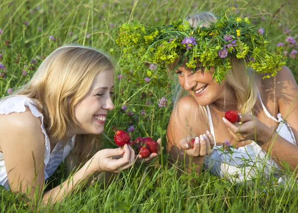 Two young blond women eating strawberries — Stock Photo, Image