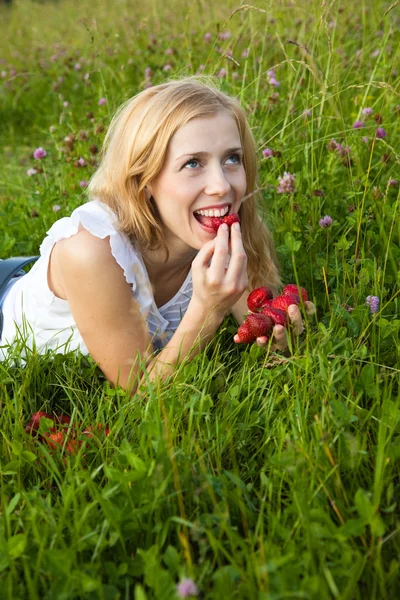 Ung blond kvinna äta jordgubbar — Stockfoto