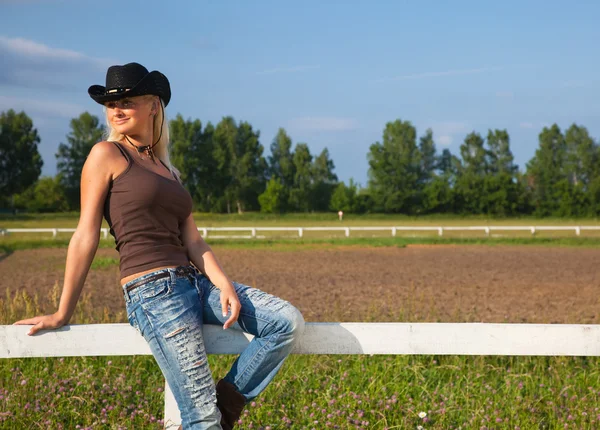 Mladí cowgirl sedí na plotě — Stock fotografie