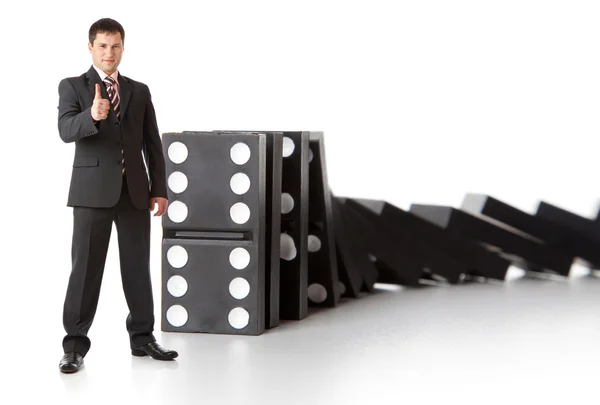 Businessman near a stack of dominoes — Stock Photo, Image