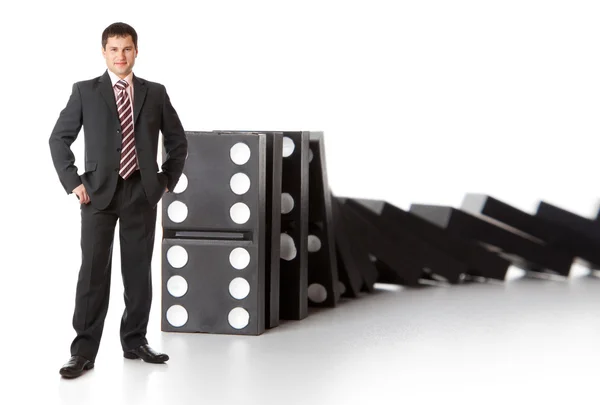 Uomo d'affari vicino a una pila di domino — Foto Stock
