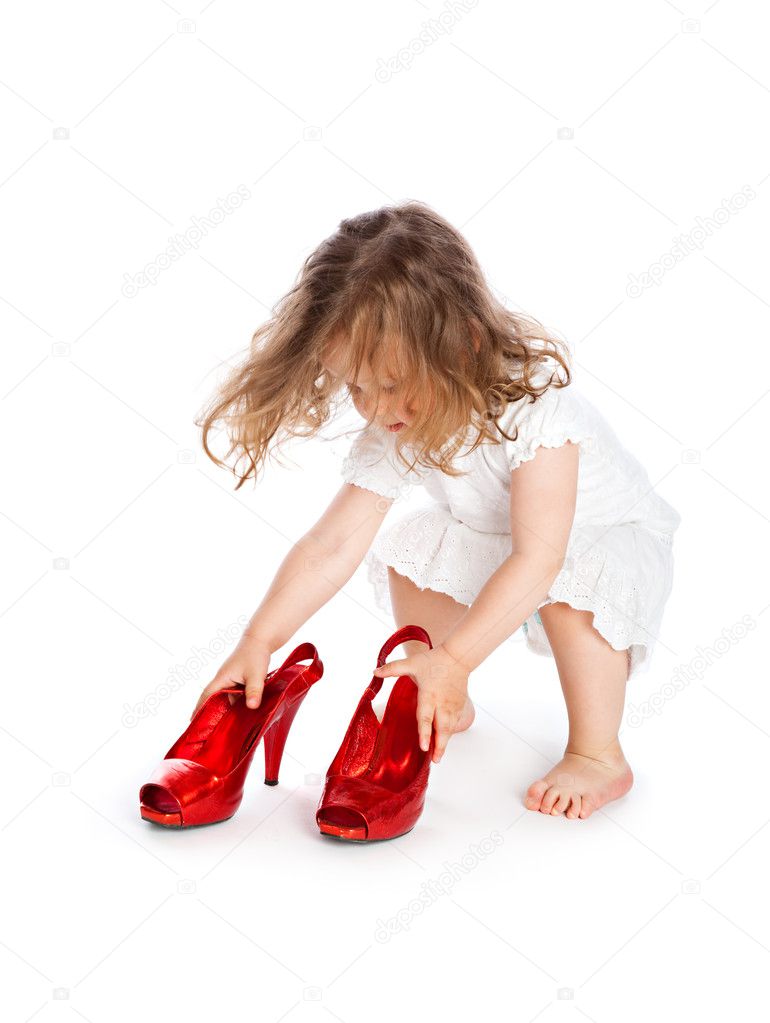 Little girl in white dress with big red shoes