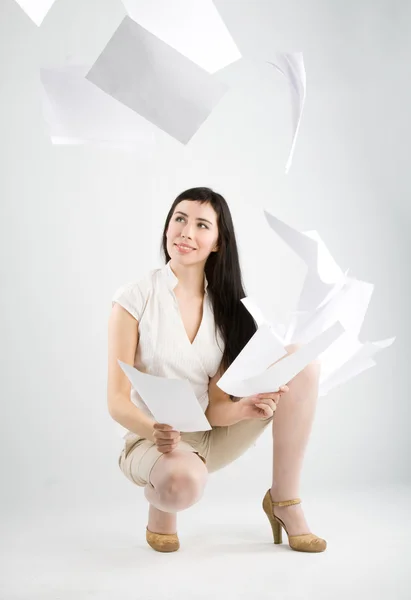 Женщина и падающая бумага — стоковое фото