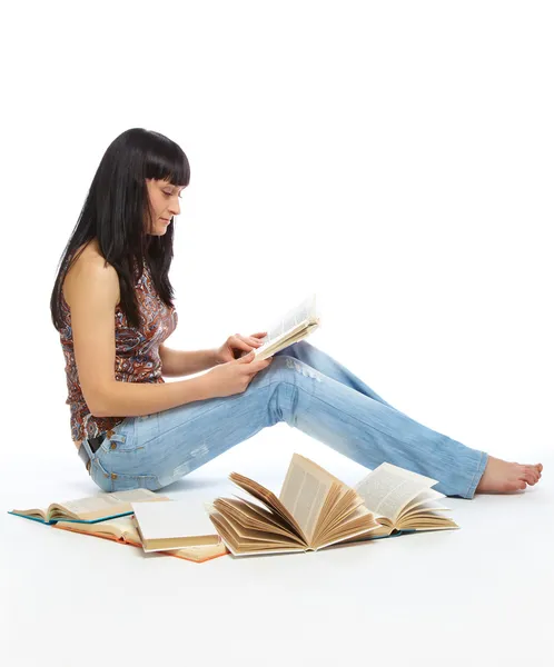 Flickan sitter på golvet och läser bok — Stockfoto