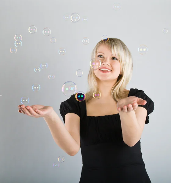 Young beautiful girl catch soap bubbles — Stock Photo, Image