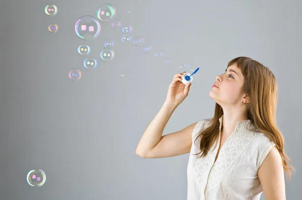 Молодая красивая девушка ловит мыльный пузырь — стоковое фото