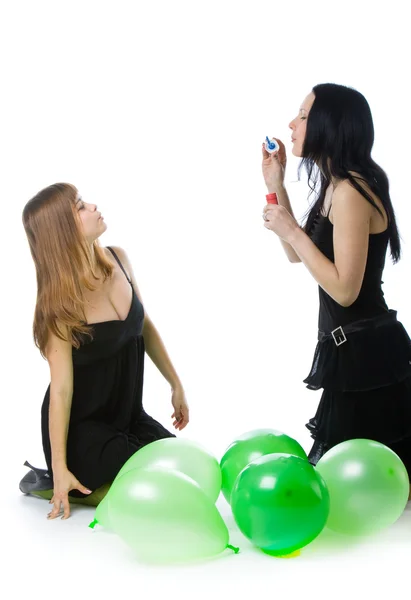 Twee jonge meisjes met groene ballons — Stockfoto