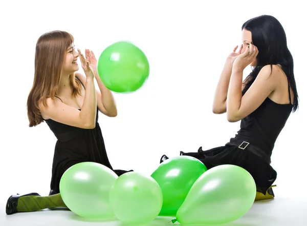 Zwei junge Mädchen mit grünen Luftballons — Stockfoto
