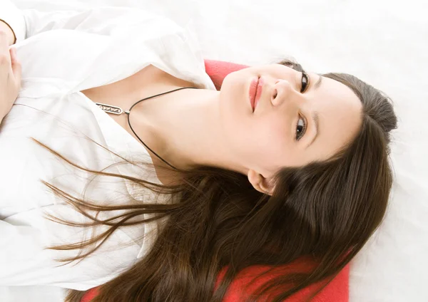 Mladá žena na červené polštář — Stock fotografie