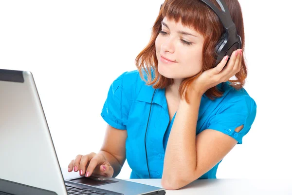 Red-haired teen-girl listen to music in headphones with laptop — Stock Photo, Image