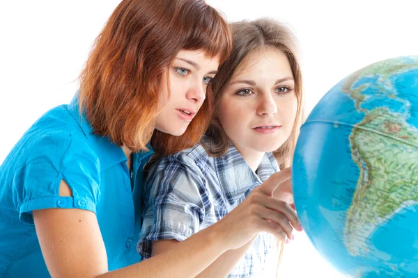 Две девочки-подростки смотрят на глобус — стоковое фото