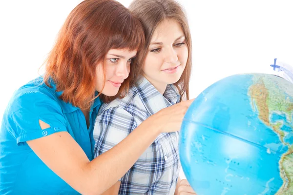Две девочки-подростки смотрят на глобус — стоковое фото