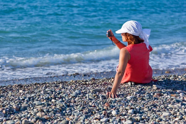一个女人与海岸上的一台照相机 — 图库照片