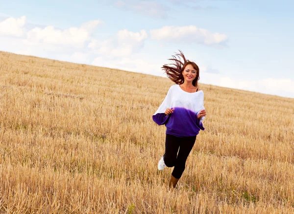 Uma mulher está correndo pelo campo — Fotografia de Stock