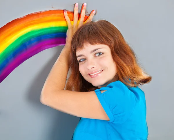 Девушка рисует радугу на стене — стоковое фото