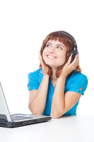 Une fille avec un ordinateur portable écoute la musique — Photo
