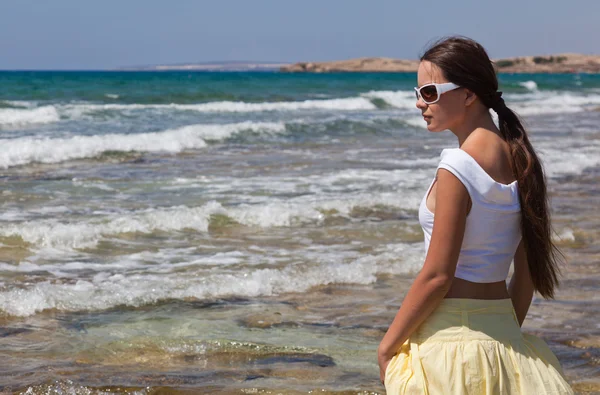 Mulher de óculos de sol está olhando para o mar — Fotografia de Stock
