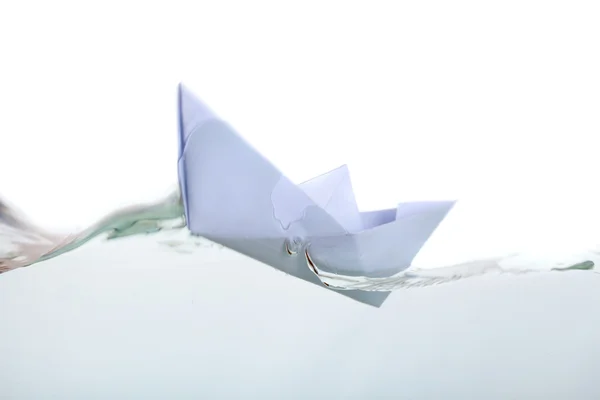 Una barca di carta in acqua trasparente — Foto Stock