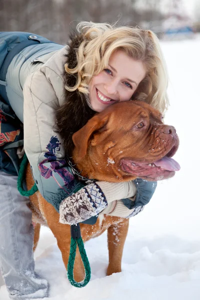 微笑着的漂亮的女人和一只狗是在冬季公园 — 图库照片