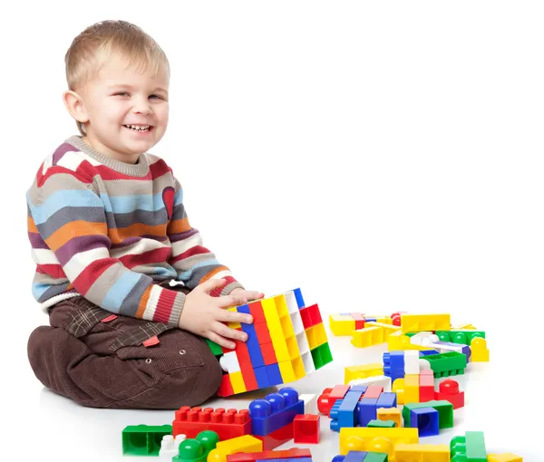 面白い少年はレゴで遊んでいます 白い背景で隔離 — ストック写真