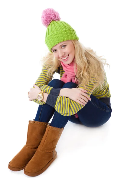 A beautiful girl in a funny cap is sitting on a floor — Stock Photo, Image