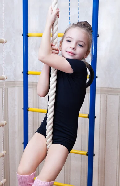 一个美丽的女孩爬上一根绳子 — 图库照片