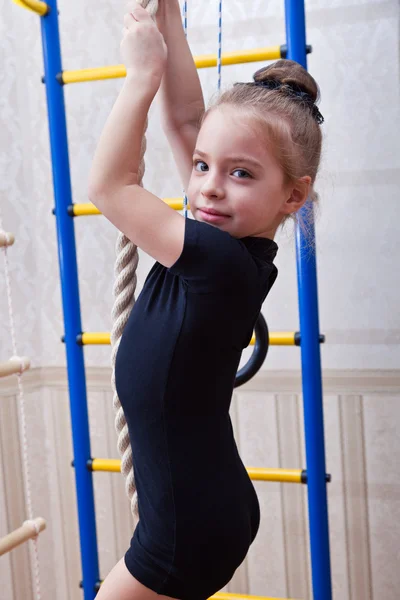 En vacker flicka klättrar på ett rep — Stockfoto