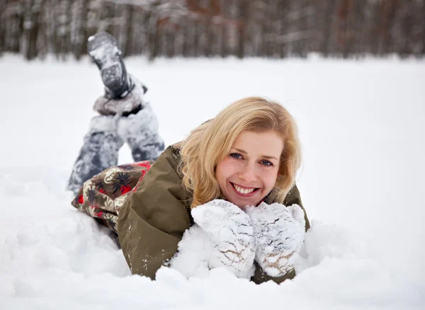 A woman is lying at the snow in the park — Stock Photo, Image