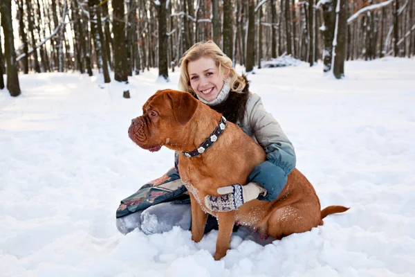 笑顔の女性は彼女の犬と雪の中で座っています — ストック写真