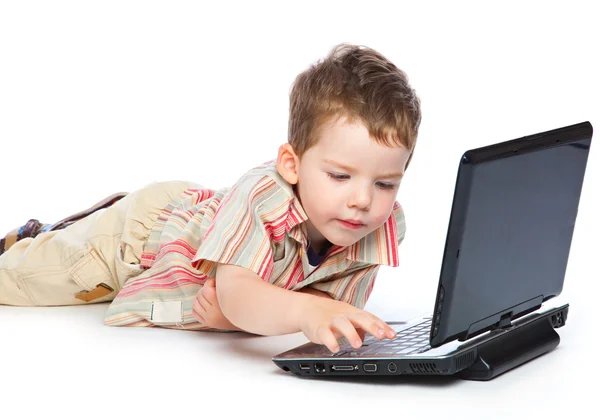 A cute boy is typing on a laptop — Stock Photo, Image