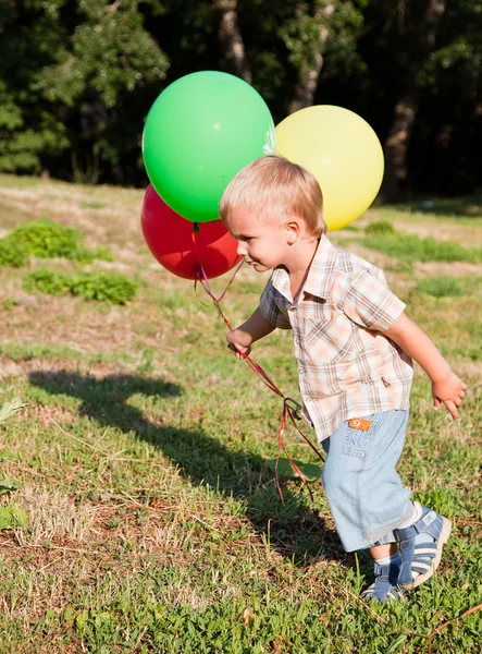 Söt Pojke Körs Gräsmatta Med Färgglada Ballonger — Stockfoto