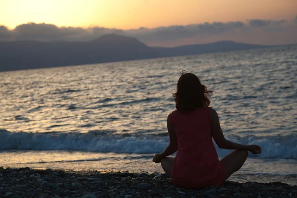 Kobieta siedzi w pozycji lotosu na plaży — Zdjęcie stockowe