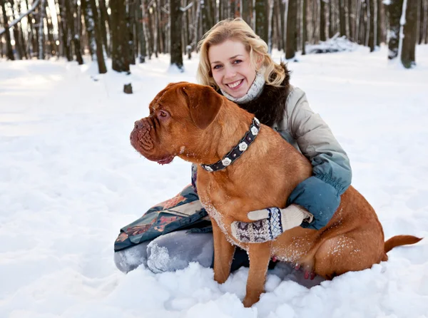 Жінка сидить на снігу зі своїм собакою — стокове фото