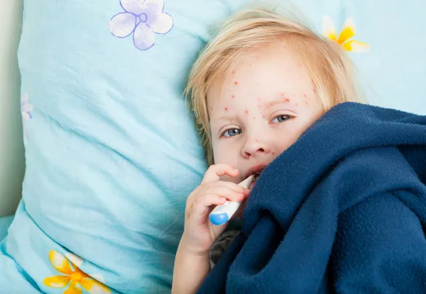 Una chica enferma está sentada cerca de la cama — Foto de Stock
