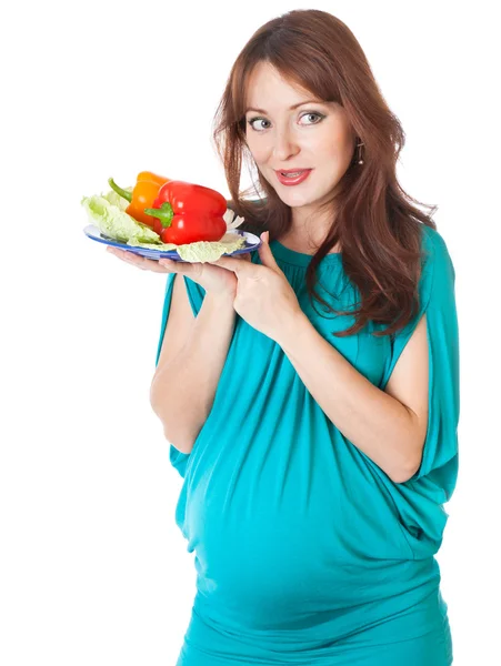 Una mujer embarazada con un plato de verduras —  Fotos de Stock