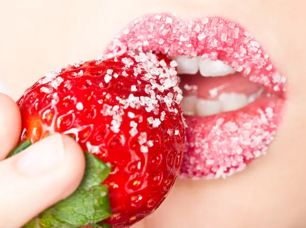 Woman's mouth with red strawberry covered with sugar — Stock Photo, Image