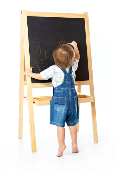 Un garçon dessine sur un tableau noir. Isolé sur fond blanc — Photo