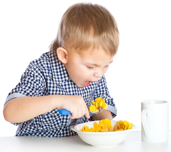 Ein Junge isst Getreide aus einer Schüssel — Stockfoto