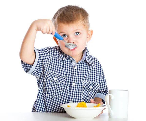 A boy is eating cereal from a bowl — Stock Photo, Image