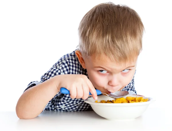 Chlapec je jíst obilí z mísy — Stock fotografie