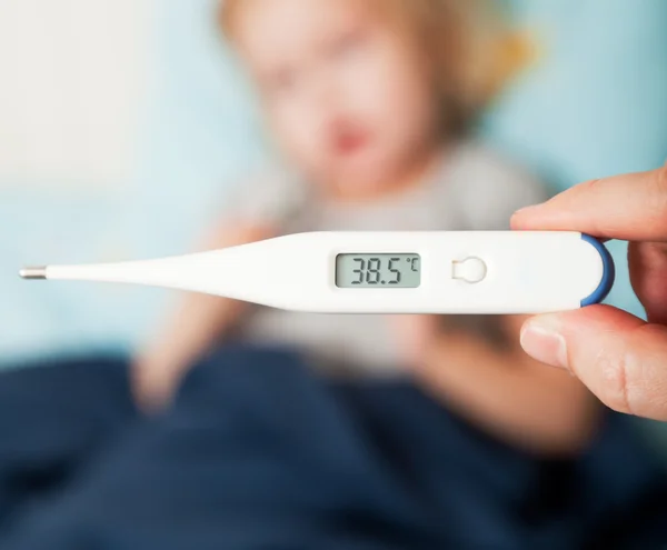 En mor mäter temperaturen på sin dotter — Stockfoto
