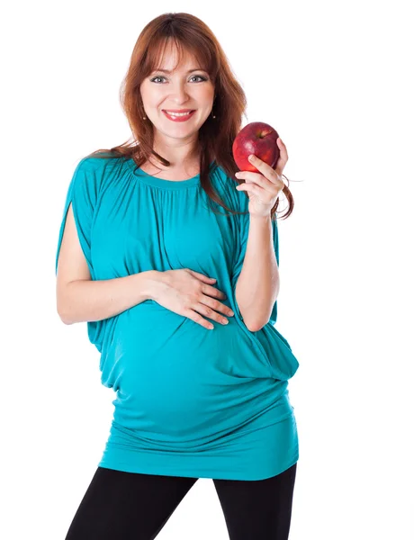 Een zwangere lachende vrouw houdt een appel in haar hand — Stockfoto