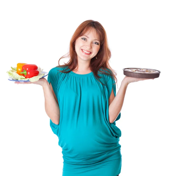 Uma mulher sorrindo grávida está segurando comida em suas mãos — Fotografia de Stock