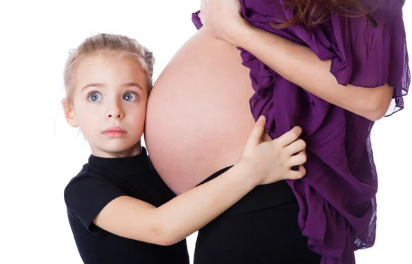 Una chica asustada está escuchando el abdomen de su madre — Foto de Stock